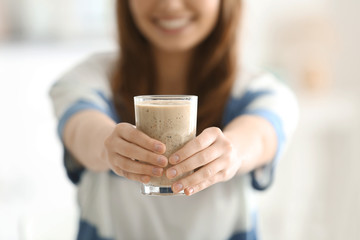 Weight loss concept. Young woman holding glass of healthy delicious smoothie, closeup