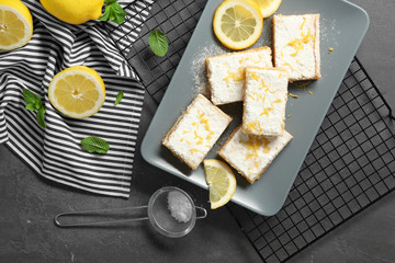 Plate with delicious lemon pie bars on cooling rack