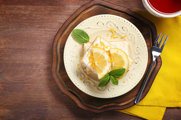 Plate with delicious lemon pie bars on wooden table