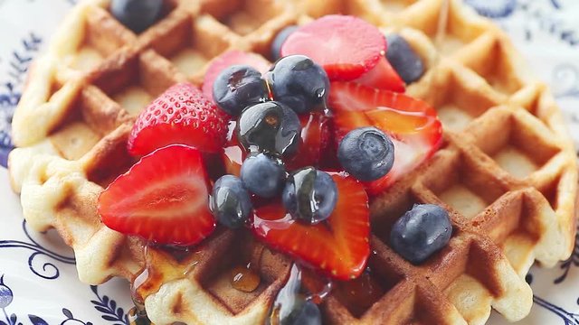 Overhead of syrup poured over fresh fruit on homemade waffle