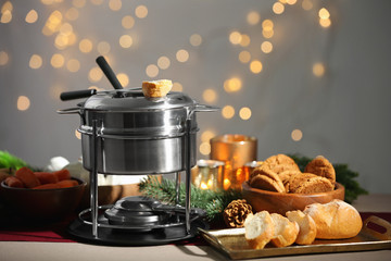 Fondue pot and fresh bread on table