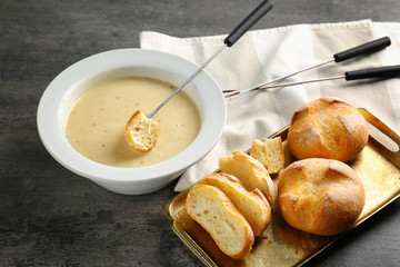 Cheese fondue and fresh bread on table