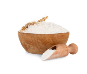 Wooden bowl and scoop with flour on white background