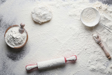 Scattered flour, dough and kitchen utensils on table