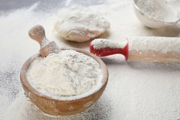 Scattered flour, dough and kitchen utensils on table