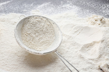 Sieve with flour on kitchen table