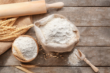 Composition with flour and kitchen utensils on wooden background