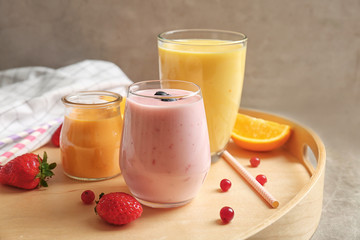 Fresh orange and blueberry yogurt smoothies on wooden tray