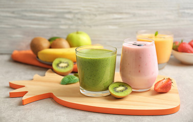 Fresh banana, kiwi and blueberry yogurt smoothies on cutting board