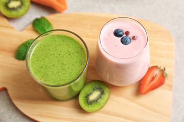 Fresh banana, kiwi and blueberry yogurt smoothies on cutting board