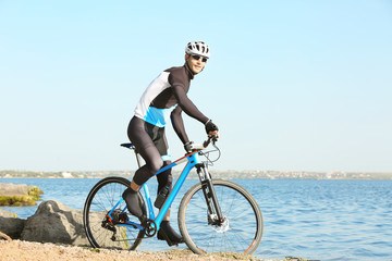 Sporty cyclist riding bicycle near river