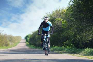 Fototapeta na wymiar Sporty cyclist riding bicycle outdoors on sunny day