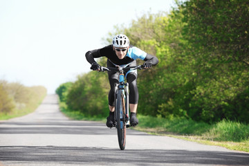 Fototapeta na wymiar Sporty cyclist riding bicycle outdoors on sunny day
