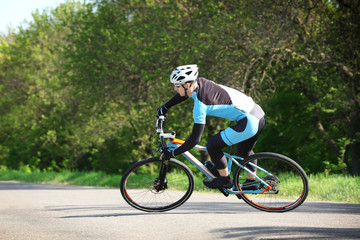 Sporty cyclist riding bicycle outdoors on sunny day