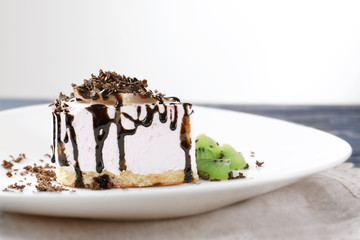 Plate with tasty cake and chocolate sauce on table, closeup