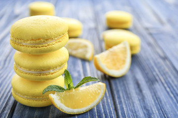 Tasty lemon macarons on wooden table, closeup