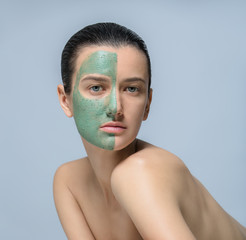 Young woman with green face mask - studio portrait