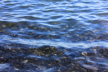 Transparent water surface with stony bottom.