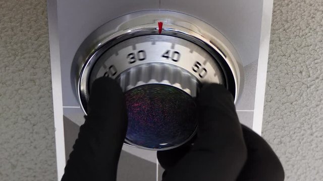 Black thief gloves open a small safe box. Emergency warning lights turn red