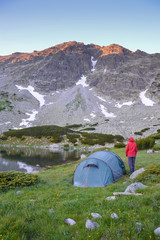 Woman and a tent in mountains