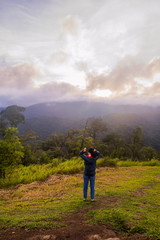 freedom girl with hands up in the mountains against sun