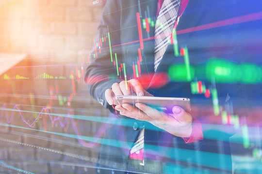 business stock chart and young and smart business man in suit using tablet with free copyspace for your  ideas text