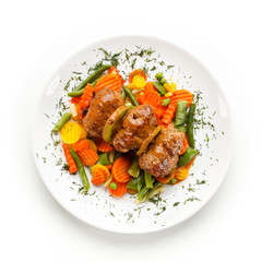Wrapped pork chops and vegetables on white background 