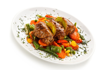 Wrapped pork chops and vegetables on white background 