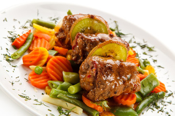 Wrapped pork chops and vegetables on white background 
