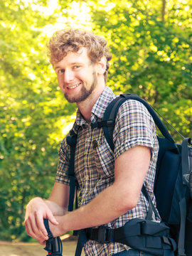 young man with backpack hiking in forest trail