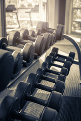 Rows of dumbbells in the gym with hign contrast and monochrome color tone