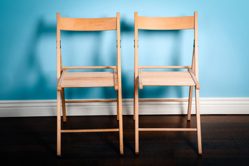 Two wooden chairs on blue background