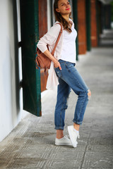 Walking young stylish casual woman standing, on tunnel, doors, street,old city, ancient street, white walls