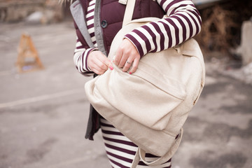 Stylish girl opens / closes a glamorous backpack