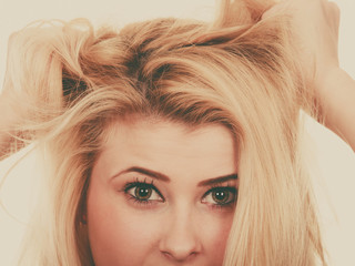 Naklejka premium Blonde woman holding her dry hair