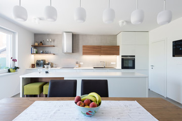 Modern kitchen interior with with built-in appliances connected with dinner room
