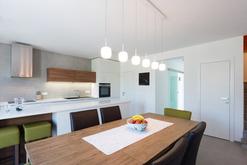 Modern kitchen interior with with built-in appliances connected with dinner room