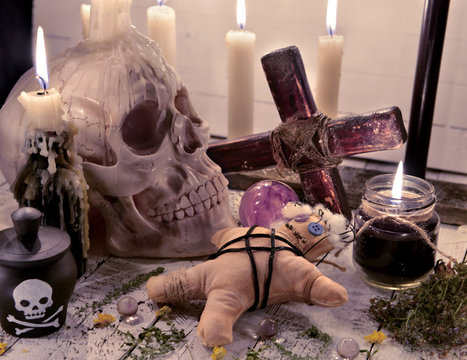 Voodoo still life with skull, doll and burning candles
