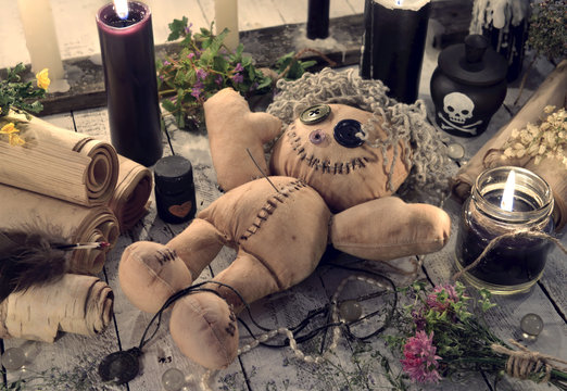 Scary voodoo doll with paper scrolls and black candles
