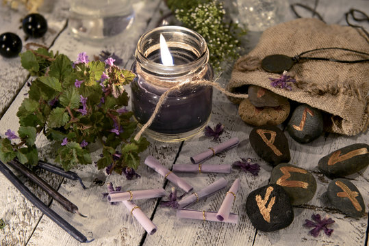 Fortune telling still life with black candle, runes and wish scroll