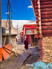 Fototapeta na wymiar Tibetan buddhist monks walking in a nerrow street at Yarchen Gar Monastery