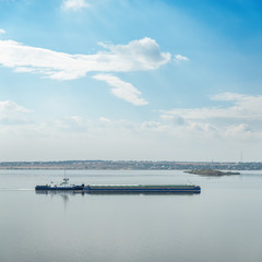 Obraz premium barges with boat on river and clouds in blue sky
