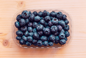Fresh blueberries in plastic container box, top view