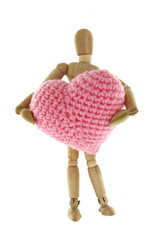 Wooden mannequin hugging heart knit with yarn