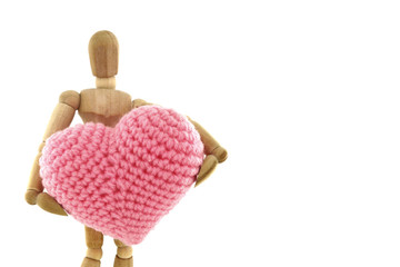 Wooden mannequin holding heart knit with yarn