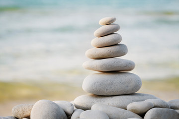 Fototapeta na wymiar Stack of white pebbles stone against sea background for spa, balance, meditation and zen theme.