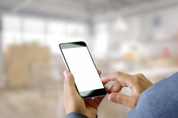 Man using Smartphone with blurred office background.