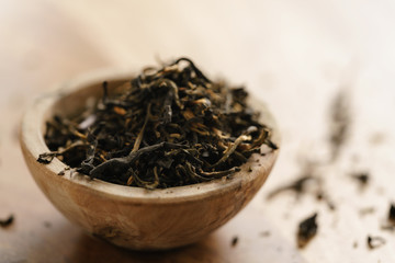golden orchid tea in small bowl on wood table