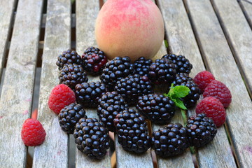 A peach with blackberries and raspberries