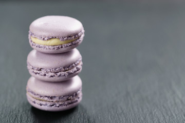 lavender purple macarons stacked on slate board